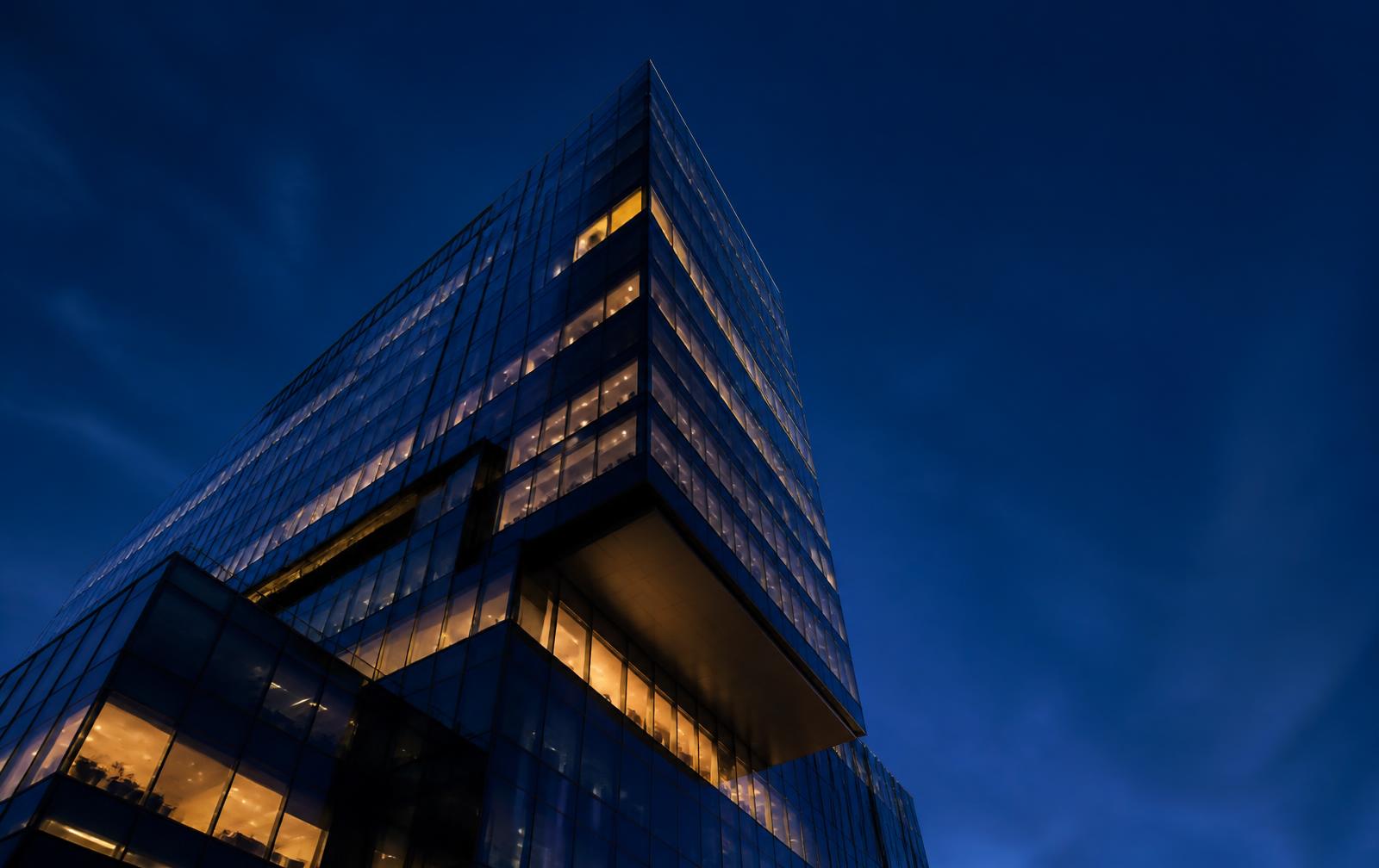 Modern glass office tower at dusk